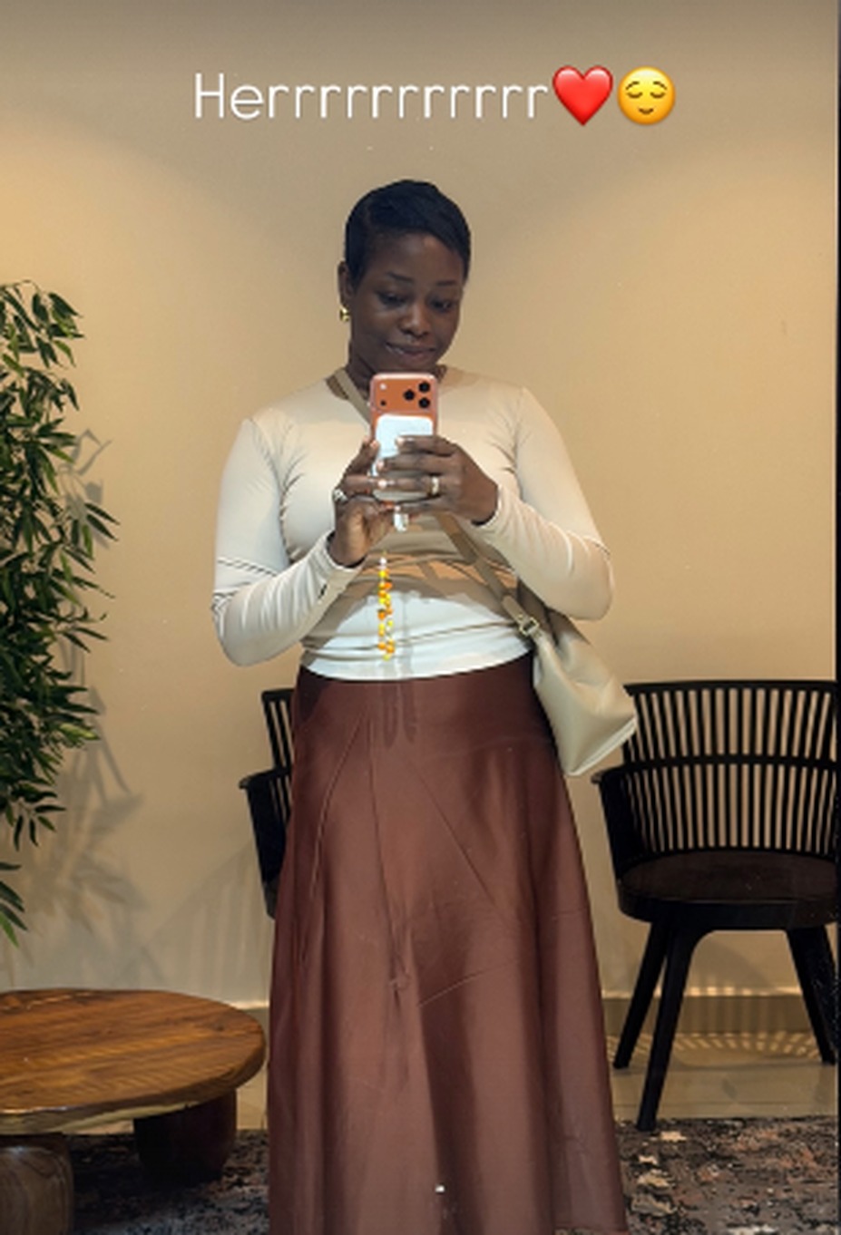 Treasure in a cream top and brown skirt